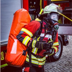 Feuerwehrmann trägt den VLITEX Tragesack mit Löschdecke auf dem Rücken im Einsatz.